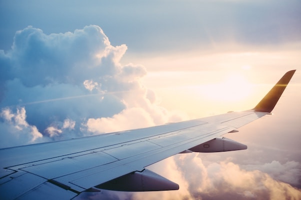 image of an airplane wing with clouds in the background.